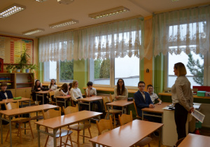 Na zdjęciu uczniowie klasy ósmej siedzący w ławkach w sali lekcyjnej podczas spotkania z doradcą.